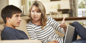 Mother And Teenage Son Arguing On Sofa