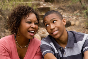 Happy single-parent and son laughing in an outdoor setting